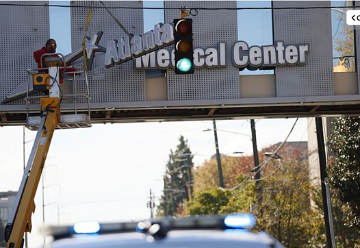 Crew members work removing the signs out of the bridge from the Atlanta Medical Center on Tuesday, November 1, 2022. The doors t