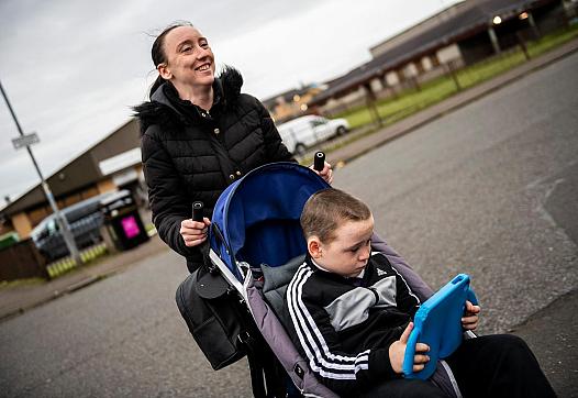 Leanne Quigley, of Possilpark, a neighborhood in Glasgow, pushes her son David Crichton, 7, back home.