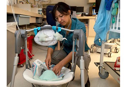 Dr. Lily Martorell-Bendezu checks an opiate-addicted baby’s heart and muscle tone in the neonatal intensive care unit at Riversi