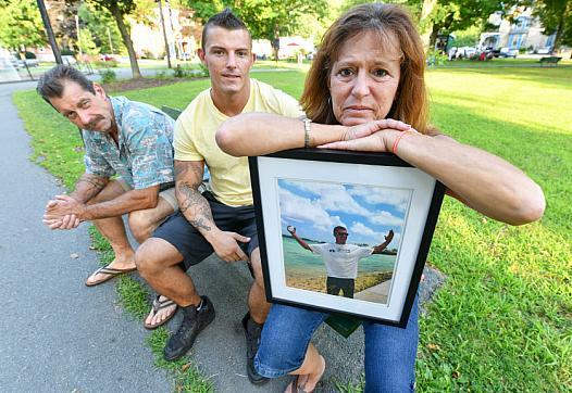Lynne Russell, of Hawley Pa., holds a photo of her late son, Patrick, on July 25, 2019, as she sits with her husband Patrick.