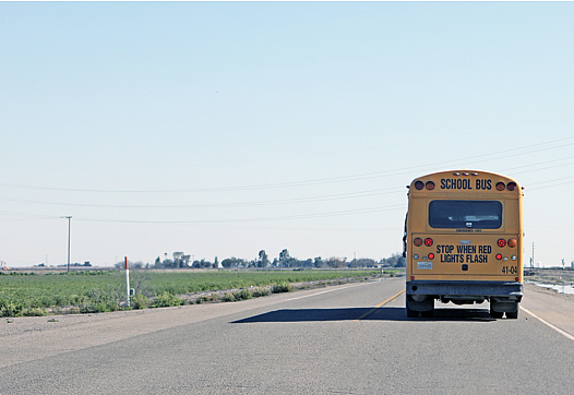 A rural school bus heads out to a campus to pick up students.