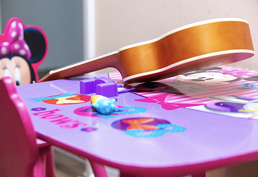 Nadia's Minnie mouse play table, with a small guitar on it.