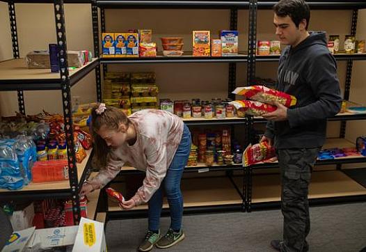 Bellarmine students stow away food items picked up at the Dare to Care food bank to be added to the university’s food pantry. Th
