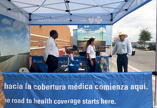 Insurance agents working with Blue Cross Blue Shield of Texas answered questions outside of a Target in San Antonio. (Veronica Zaragovia/KUT)