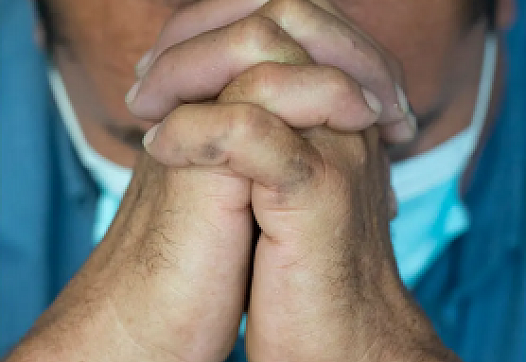 Man folds hands to pray